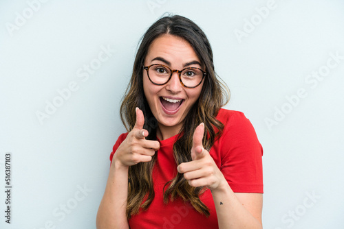 Young caucasian woman isolated on blue background cheerful smiles pointing to front.