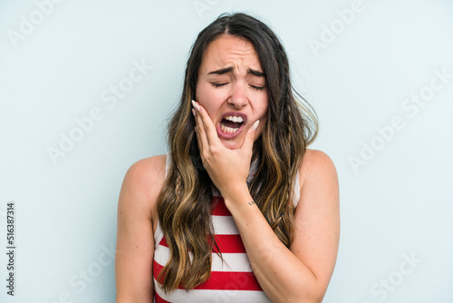 Young caucasian woman isolated on blue background having a strong teeth pain, molar ache.
