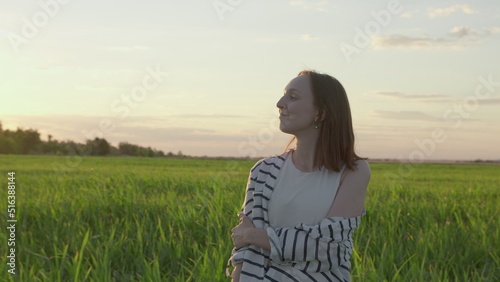 4K. Happy young woman posing at sunset in a field.