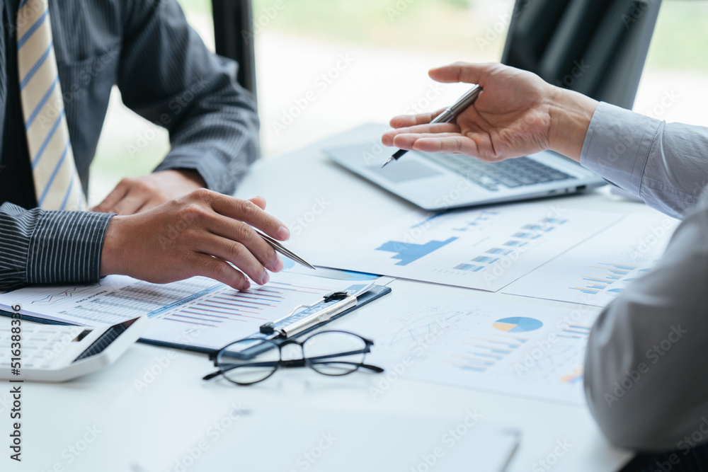 Group of business people meeting, discussing, analyzing graphs, financial data, and planning a marketing project together Group of business people meeting, discussing, analyzing graphs, financial data, and planning a marketing project together