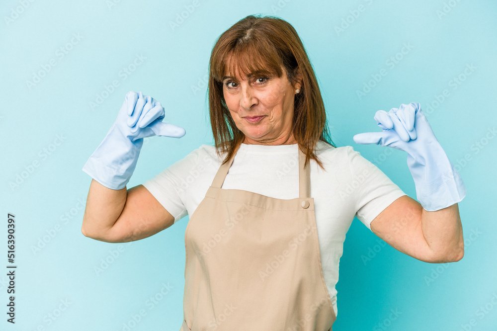 Middle age caucasian woman cleaning home isolated on blue background feels proud and self confident, example to follow. Middle age caucasian woman cleaning home isolated on blue background feels proud and self confident, example to follow.