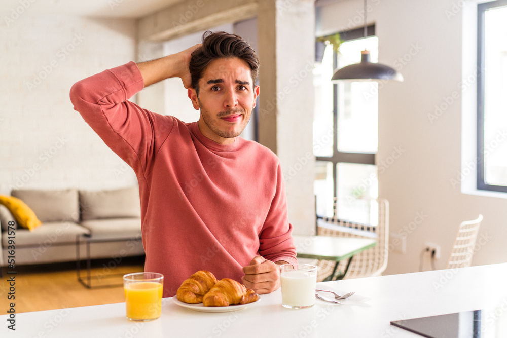Young mixed race man having breakfast in a kitchen on the morning being shocked, she has remembered important meeting. Young mixed race man having breakfast in a kitchen on the morning being shocked, she has remembered important meeting.