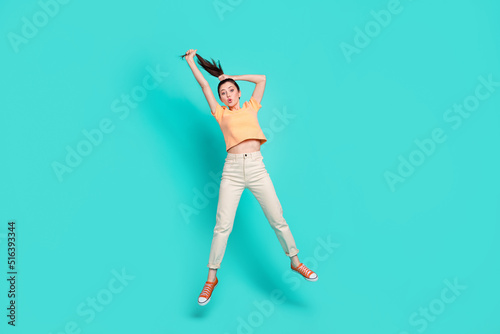 Full length portrait of impressed nice person jump pouted lips arms hold hair isolated on turquoise color background