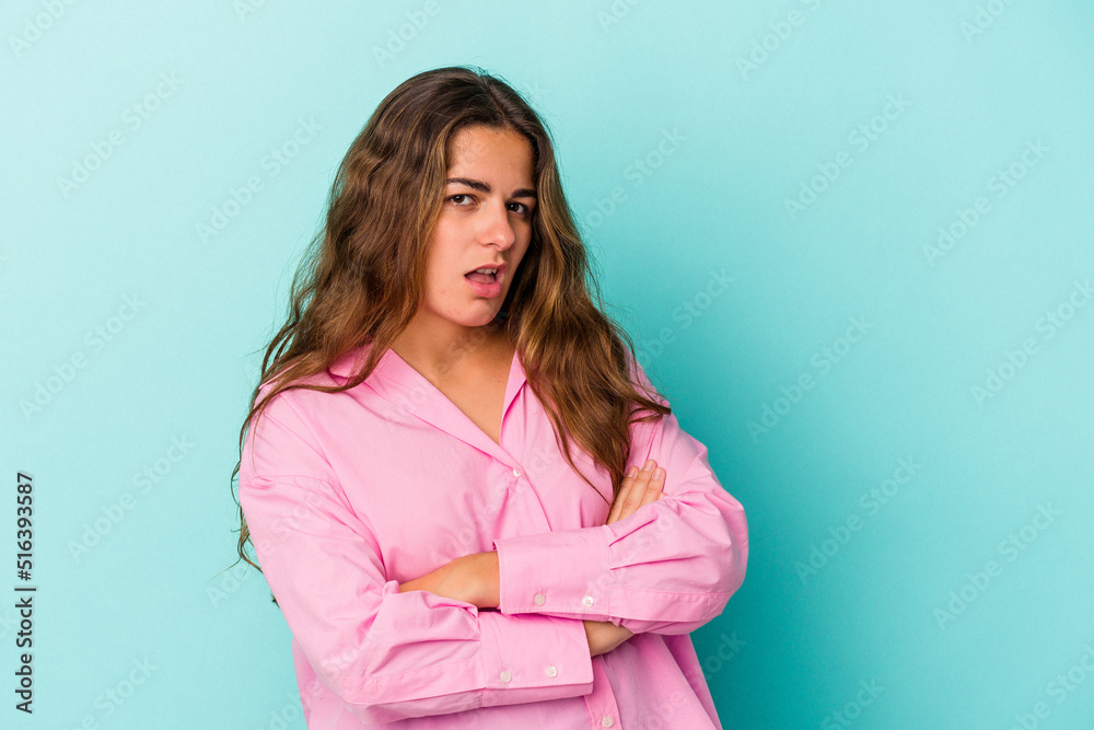 Young caucasian woman isolated on blue background who is bored, fatigued and need a relax day. Young caucasian woman isolated on blue background who is bored, fatigued and need a relax day.