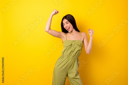 Photo of delighted overjoyed thai person raise fists triumph attainment isolated on yellow color background © deagreez