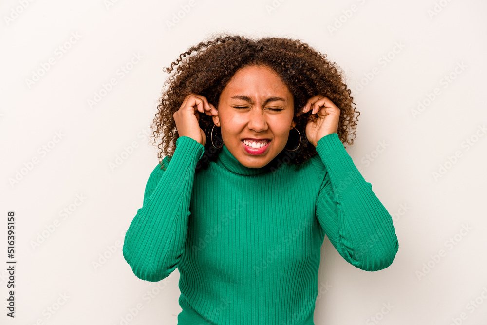 Young African American woman isolated on white background covering ears with hands. Young African American woman isolated on white background covering ears with hands.