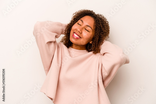 Young African American woman isolated on white background feeling confident, with hands behind the head. © Asier