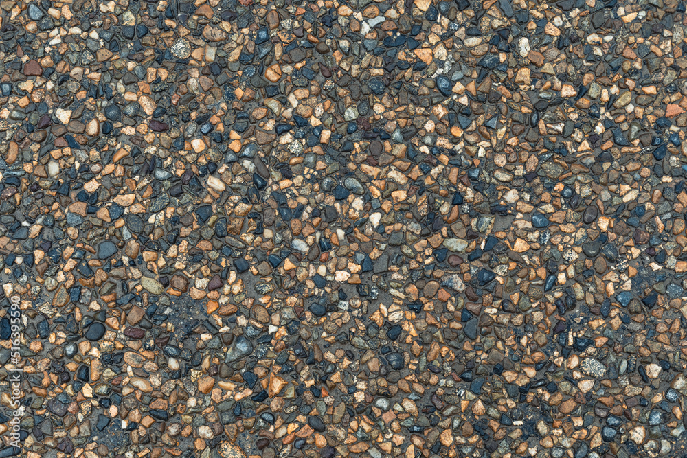 Texture of small multi-colored stones. Asphalt background.