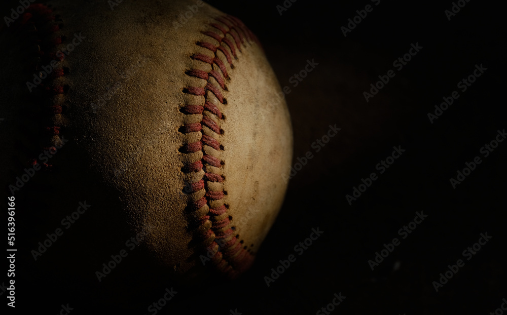Old used baseball ball closeup, isolated on dark black background with copy space. Old used baseball ball closeup, isolated on dark black background with copy space.