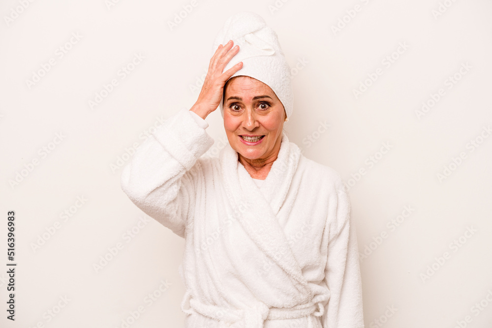 Middle age caucasian woman wearing a bathrobe isolated on white background being shocked, she has remembered important meeting. - obrazy, fototapety, plakaty 