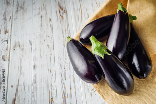 fresh natural eggplant on a light white wooden rustic background