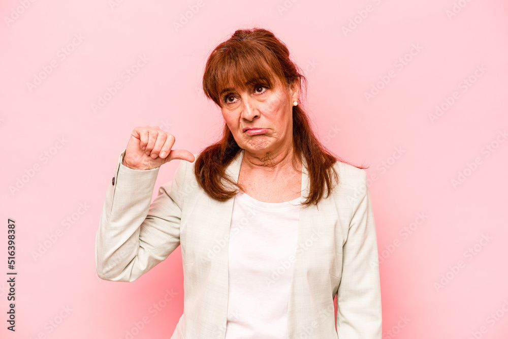 Middle age caucasian woman isolated on pink background showing a dislike gesture, thumbs down. Disagreement concept. Middle age caucasian woman isolated on pink background showing a dislike gesture, thumbs down. Disagreement concept.
