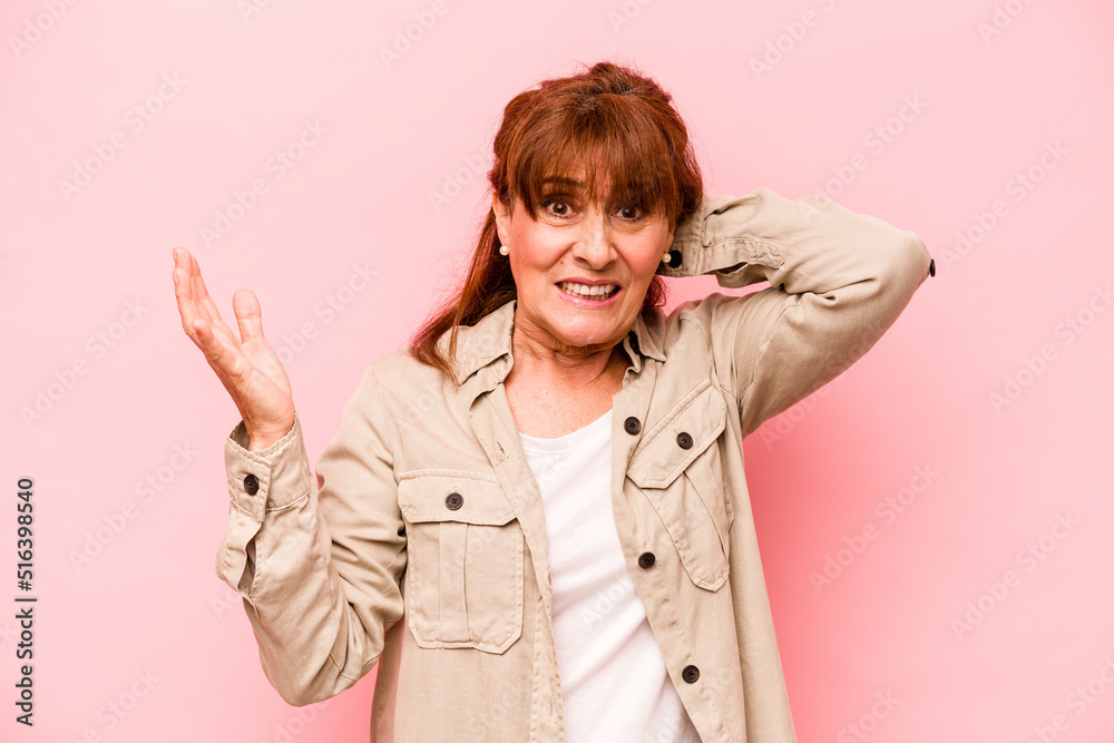 Middle age caucasian woman isolated on pink background screaming with rage. Middle age caucasian woman isolated on pink background screaming with rage.