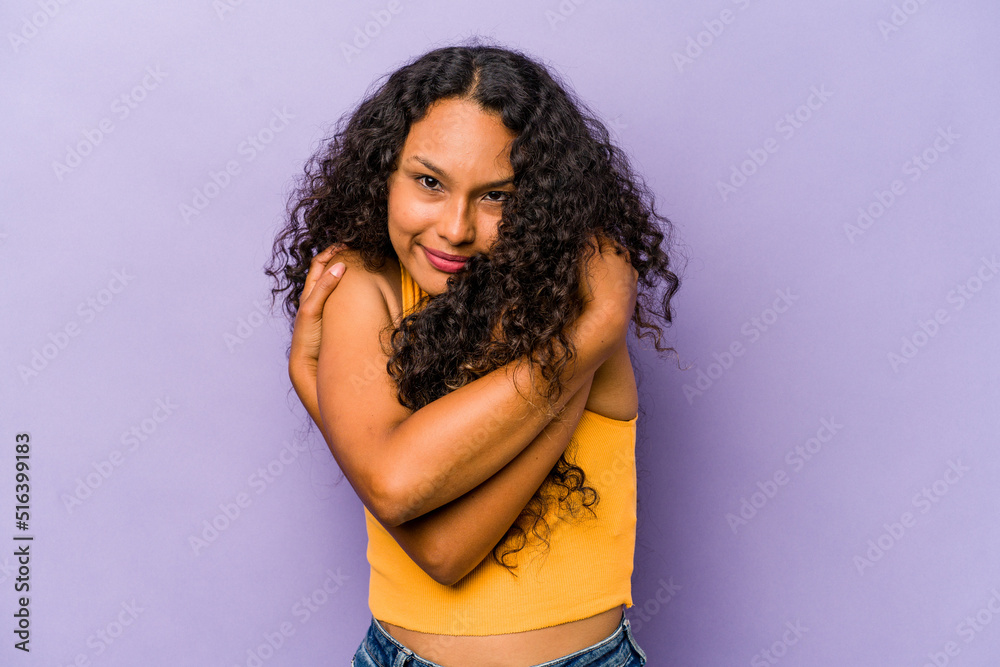 Young hispanic woman isolated on purple background hugs, smiling carefree and happy. Young hispanic woman isolated on purple background hugs, smiling carefree and happy.