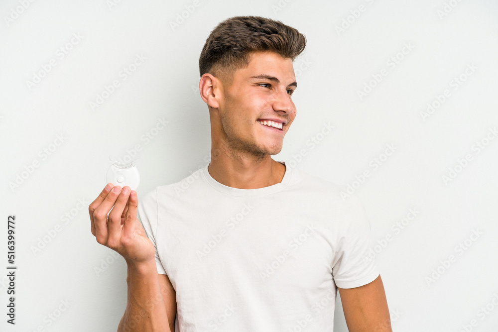 Young caucasian man hand sling isolated on white background looks aside smiling, cheerful and pleasant. Young caucasian man hand sling isolated on white background looks aside smiling, cheerful and pleasant.