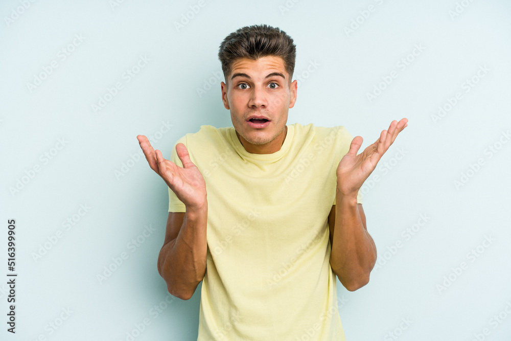 Young caucasian man isolated on blue background surprised and shocked. Young caucasian man isolated on blue background surprised and shocked.