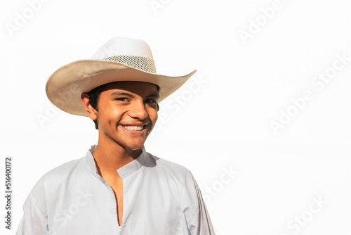 Male teenager with hat and traditional clothes from latin america smiling on white background © Carlos