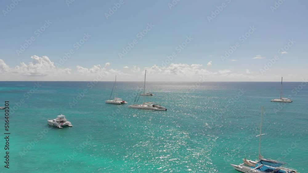 Drone shot of boats on the water close to the paradise shore