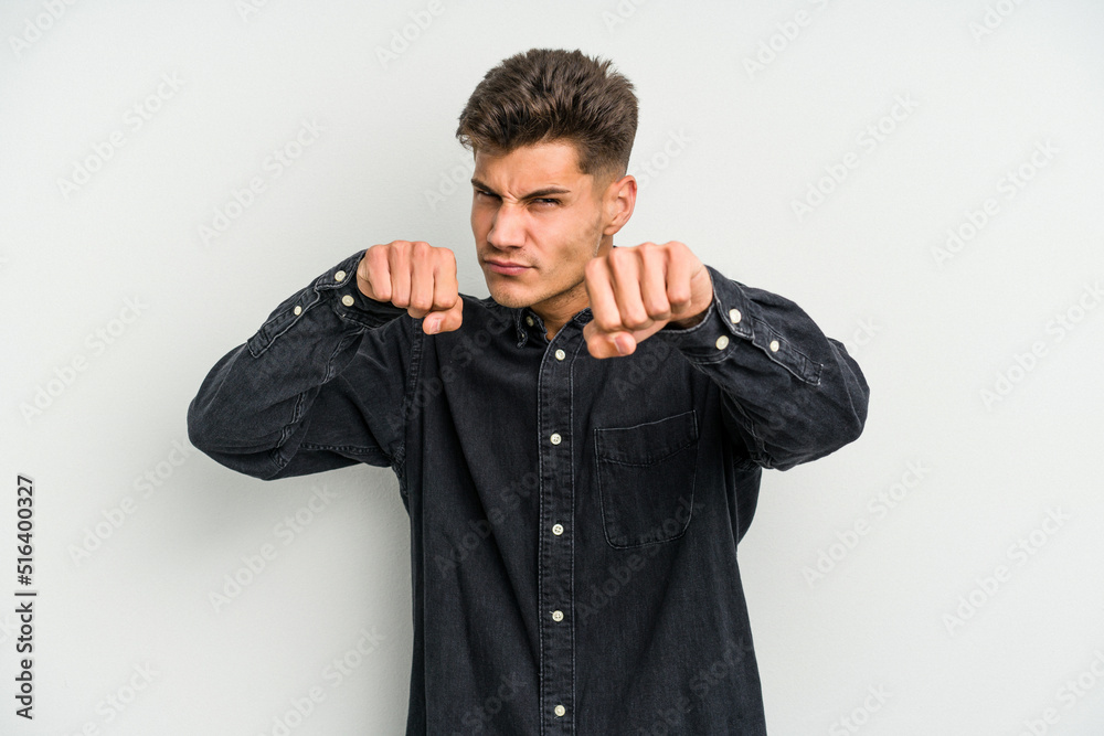 Young caucasian man isolated on white background throwing a punch, anger, fighting due to an argument, boxing. Young caucasian man isolated on white background throwing a punch, anger, fighting due to an argument, boxing.