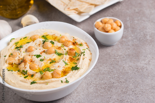 Hummus in a plate with chickpeas, smoked paprika, olive oil and pita. Vegetarian food.