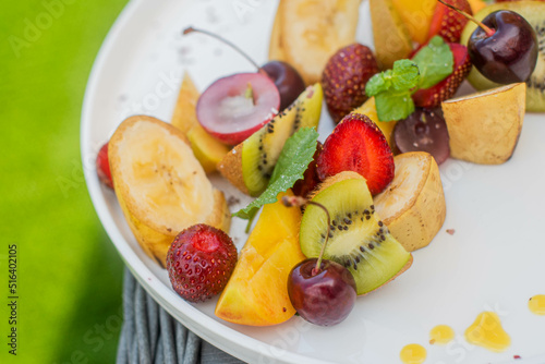 Fruit plate. Kiwi  bananas  cherries  strawberries and peaches on a plate