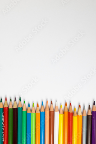 Composition of colorful crayons on white surface with copy space