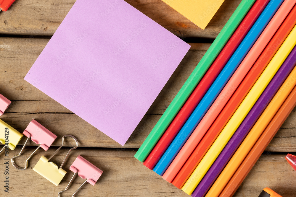 Obraz premium Composition of crayons, post it and clips on wooden surface