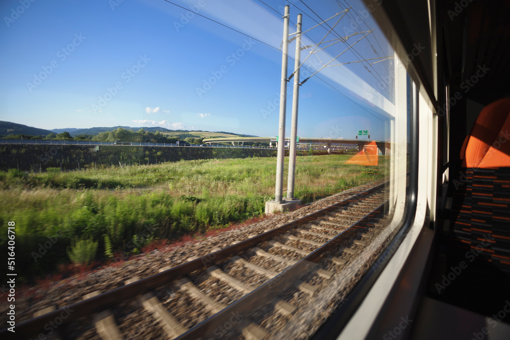 Going by train and watching landscape from the window. Travelling by public transport. Dynamic shot with motion blur, wide angle distortion and focus on distance. Going by train and watching landscape from the window. Travelling by public transport. Dynamic shot with motion blur, wide angle distortion and focus on distance.