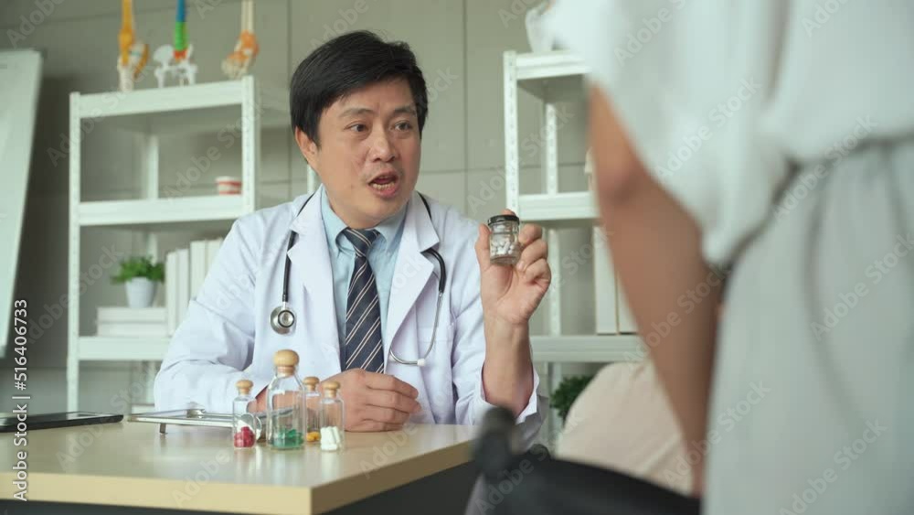 Male doctor giving medicine and explain how to take medicine Let the elderly female patients and their daughters listen in the hospital. Male doctor giving medicine and explain how to take medicine Let the elderly female patients and their daughters listen in the hospital.