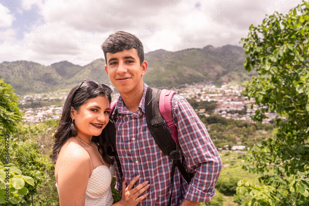 Latin teen couple smiling and looking at camera on a mountain Latin teen couple smiling and looking at camera on a mountain