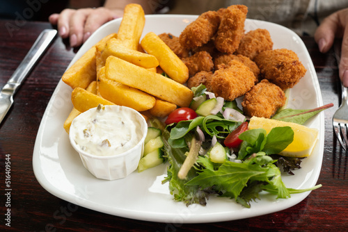 Tableau sur toile Shallow focus on scampi and chips with salad and a tub of tartare sauce