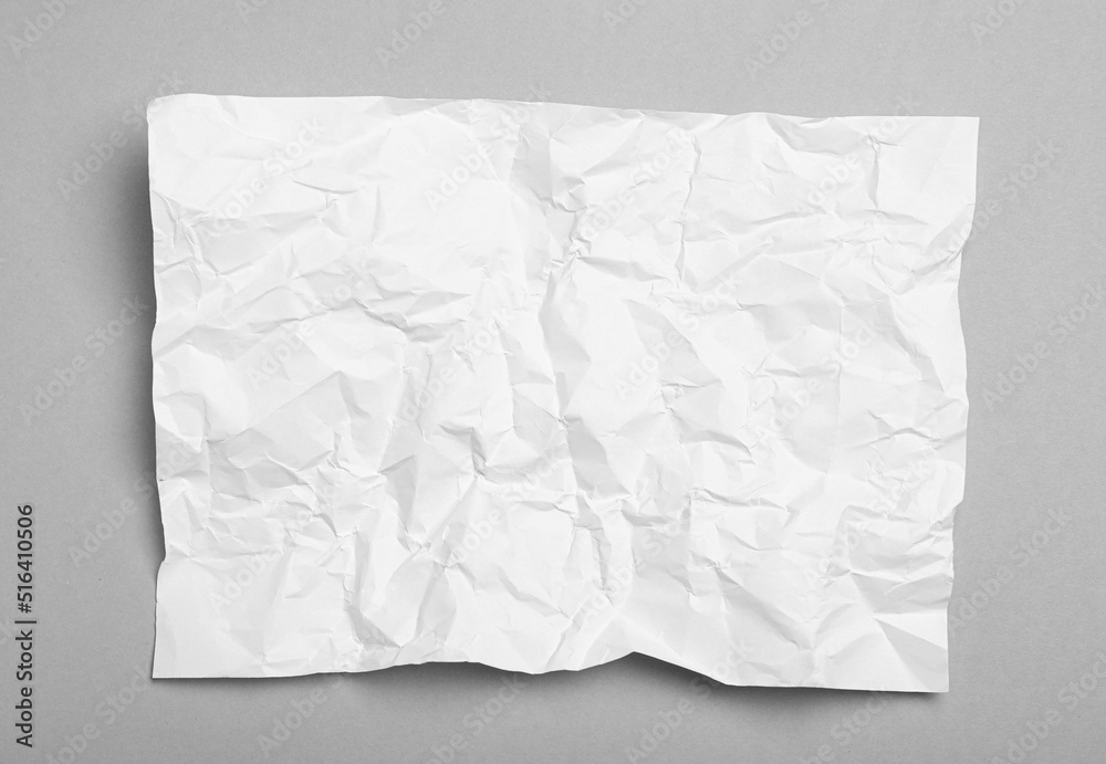 Sheet of white crumpled paper on grey background, top view Sheet of white crumpled paper on grey background, top view