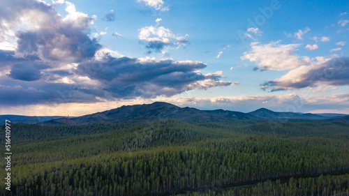 Aerial view above a beautiful landscape with a river while sunset. Aerial view from drone flies over beautiful summer landscape.