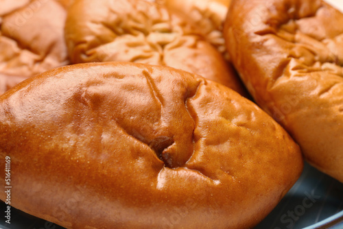 Many delicious baked patties on plate, closeup photo