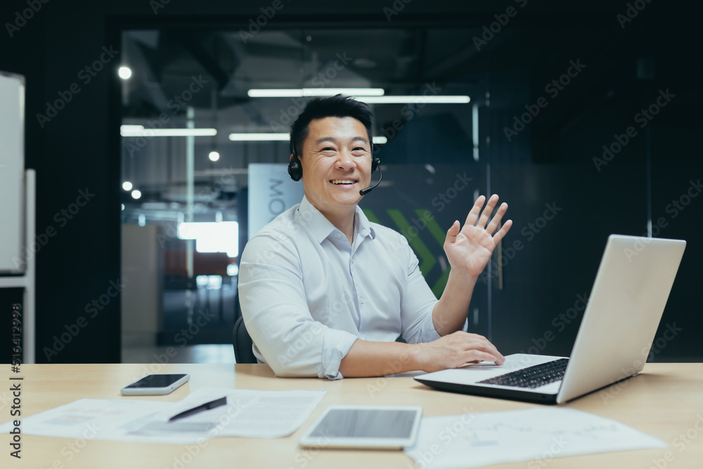 Portrait of Asian businessman man looking at camera and waving greeting gesture, man with headset for video call Portrait of Asian businessman man looking at camera and waving greeting gesture, man with headset for video call