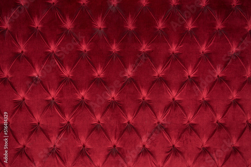Quilted velour buttoned burgundy red color fabric wall pattern background. Elegant vintage luxury sofa upholstery. Interior plush backdrop photo