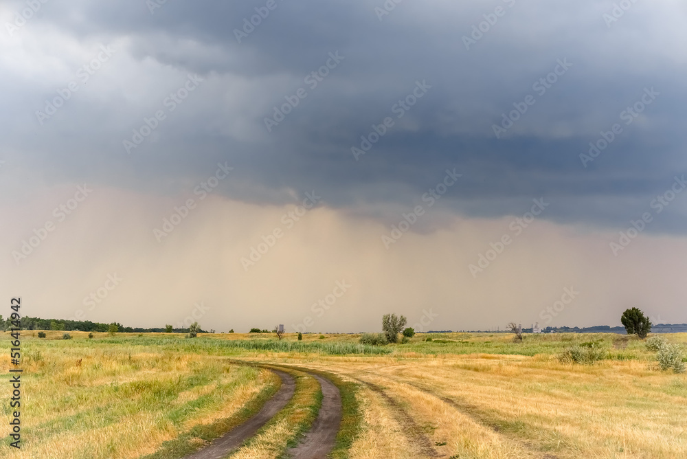 Dirt road of local importance with a stormy sky.