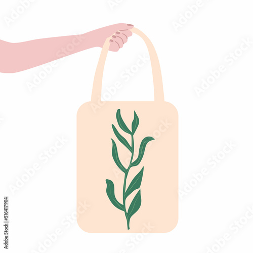 Hand holding eco canvas tote bag with green leaf. Handmade shopping bags.