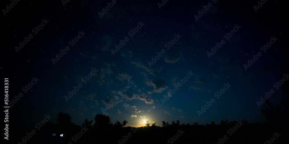 Moonset in the night sky with stars