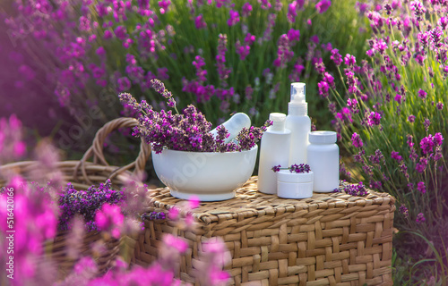 Lavender cosmetics in a field with flowers. Selective focus.