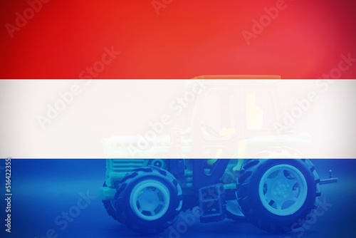Dutch flag with a tractor as background, concept of farmer protest. photo