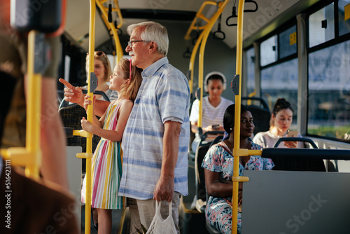 Tableau sur toile Senior man and granddaughter in public transport