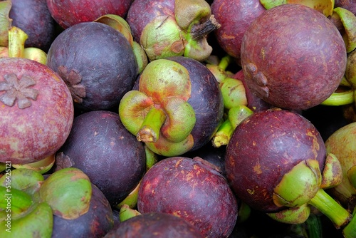 Whole mangosteen fruits on sale at a market stall photo