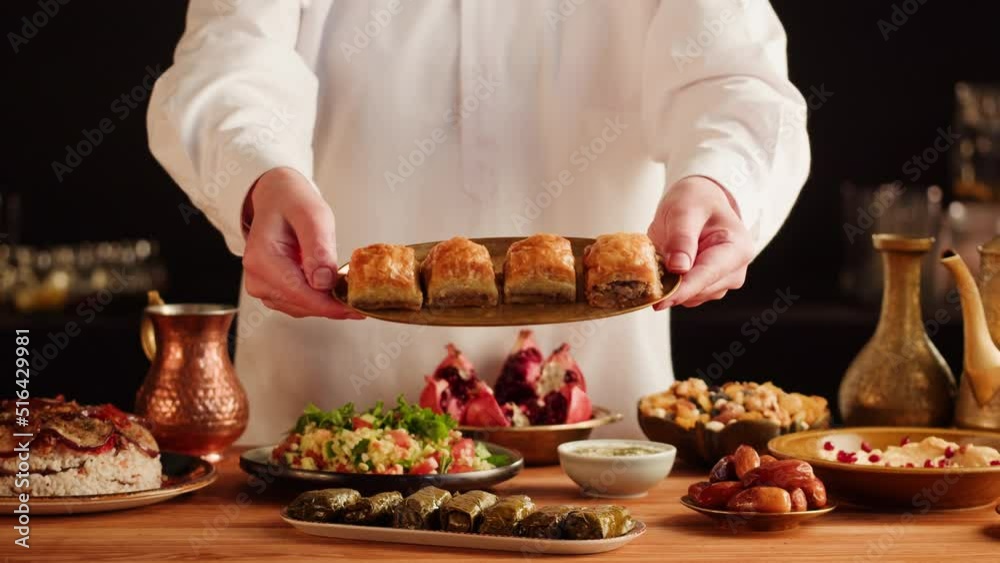 Turkish traditional food, sweet dish, Baklava close-up. Arabian cuisine, treats. Middle eastern national sugar dessert snack. Dolma, hummus, nuts and tabbouleh on table.