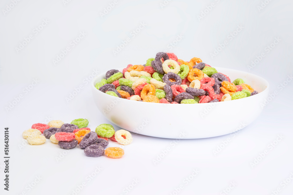 Delicious and nutritious fruit cereal loops multicolored flavorful on white background, healthy and funny addition to kids breakfast