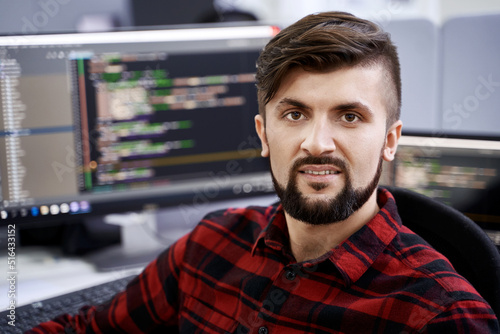 Obraz na płótnie Computer programmer developer working in IT office, sitting at desk and coding, working on a project in software development company or startup. w salonie