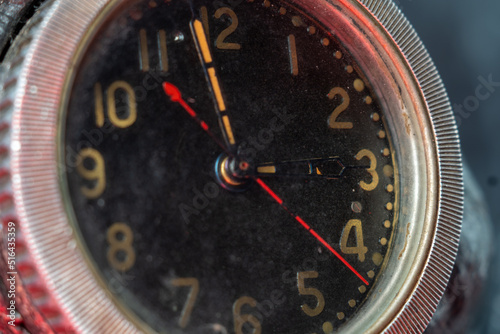 Clock face, close up. Arrows with phosphorescent, fluorescent paint that contains radioactive elements. Dangerous things at home. Old clock. photo