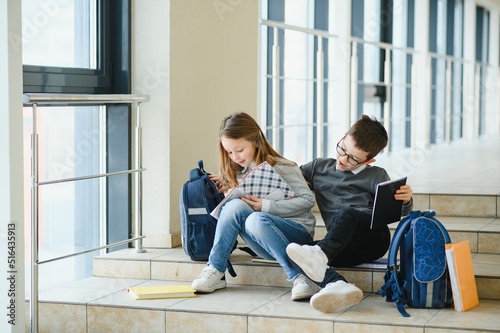 School kids with books together in corridor. Conception of education.