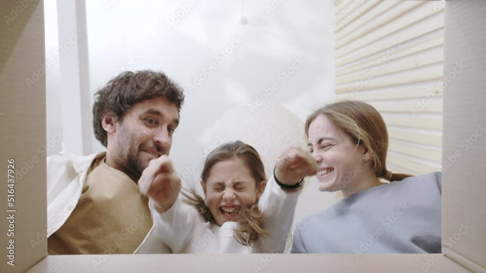 Young parents with daughter unpacking box with happiness Young parents with daughter unpacking box with happiness