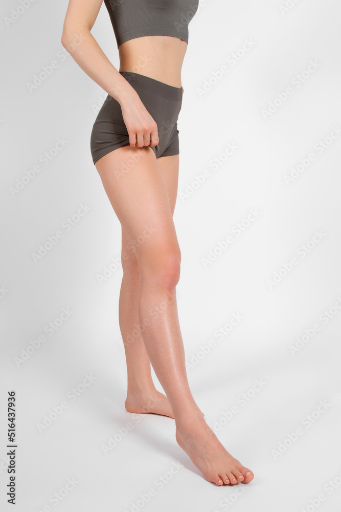 Perfect body shape close up on white background. Great figure of a tanned woman. Parts of a female body in underwear studio shot. Sportswear and yoga wear. Healthy lifestyle, skin, waist abs athletic Perfect body shape close up on white background. Great figure of a tanned woman. Parts of a female body in underwear studio shot. Sportswear and yoga wear. Healthy lifestyle, skin, waist abs athletic